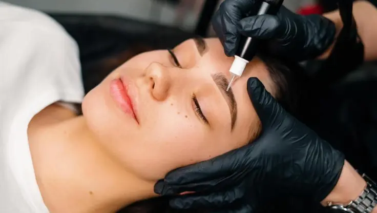 A woman gets professional skin care therapy treatment from a specialist in eyebrow transplantation.